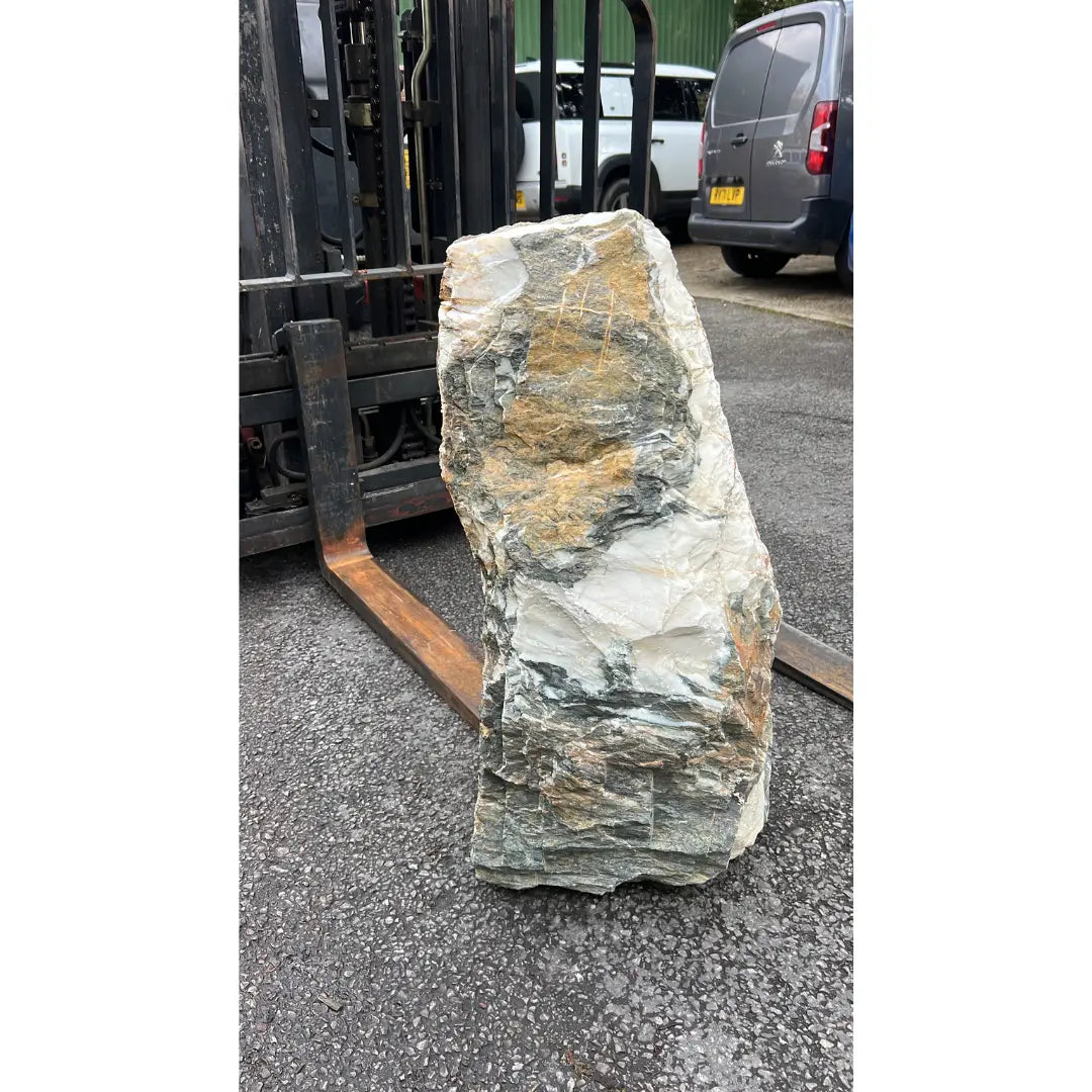 Gold and grey garden stone monolith standing upright, a refined natural feature for contemporary gardens.