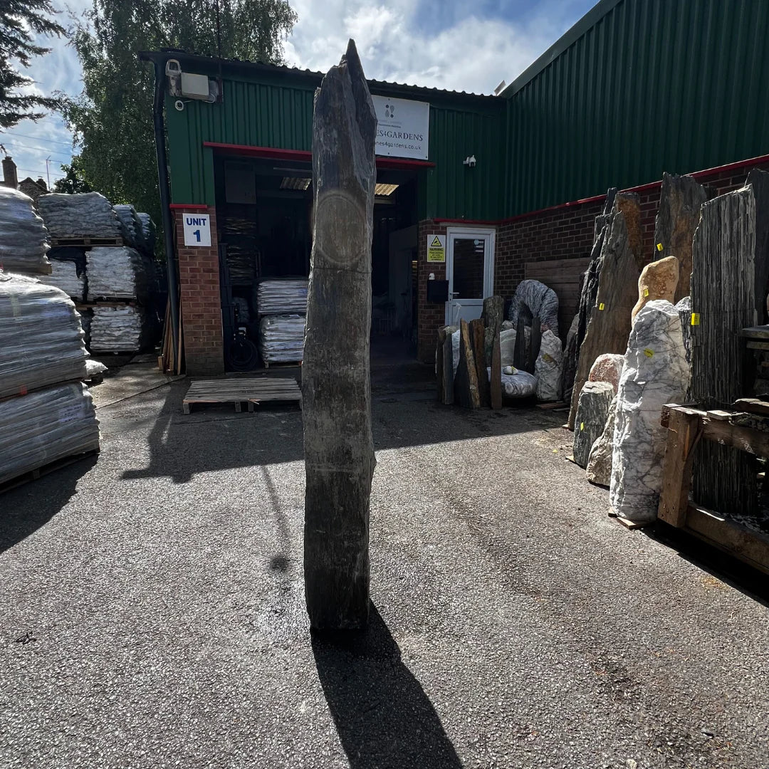 Decorative garden stone monolith used as a landscape feature among gravel and pebbles in outdoor spaces.