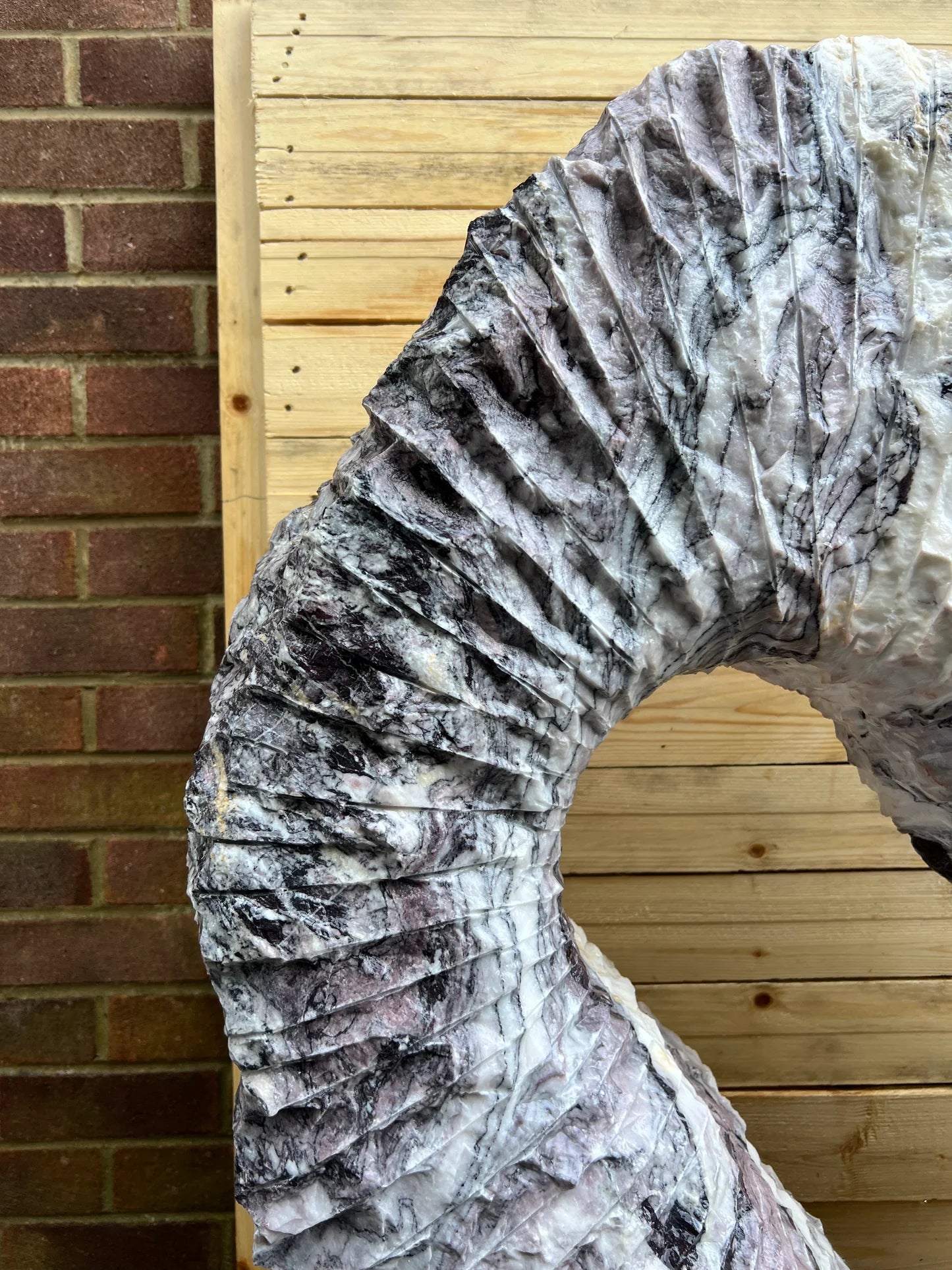 Natural Leylak marble garden monolith featuring intricate stone layers and polished craftsmanship from Italian quarries.