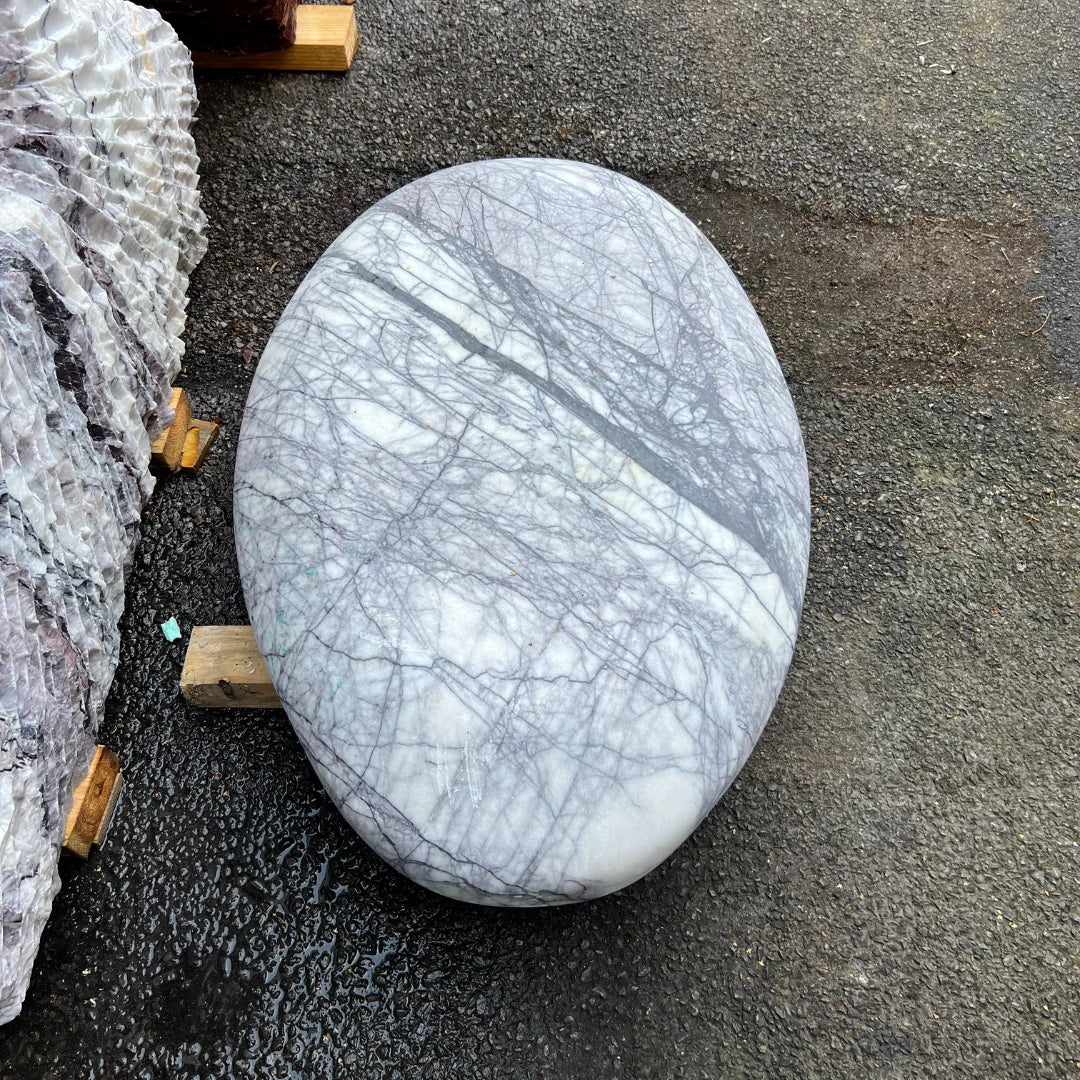 Natural marble pillow monolith from Italy, blending refined craftsmanship and natural beauty for UK garden spaces.