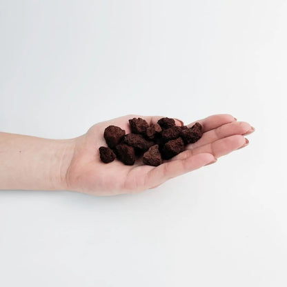 red lava gravel rocks on woman hand used for decorative gardening purposes.