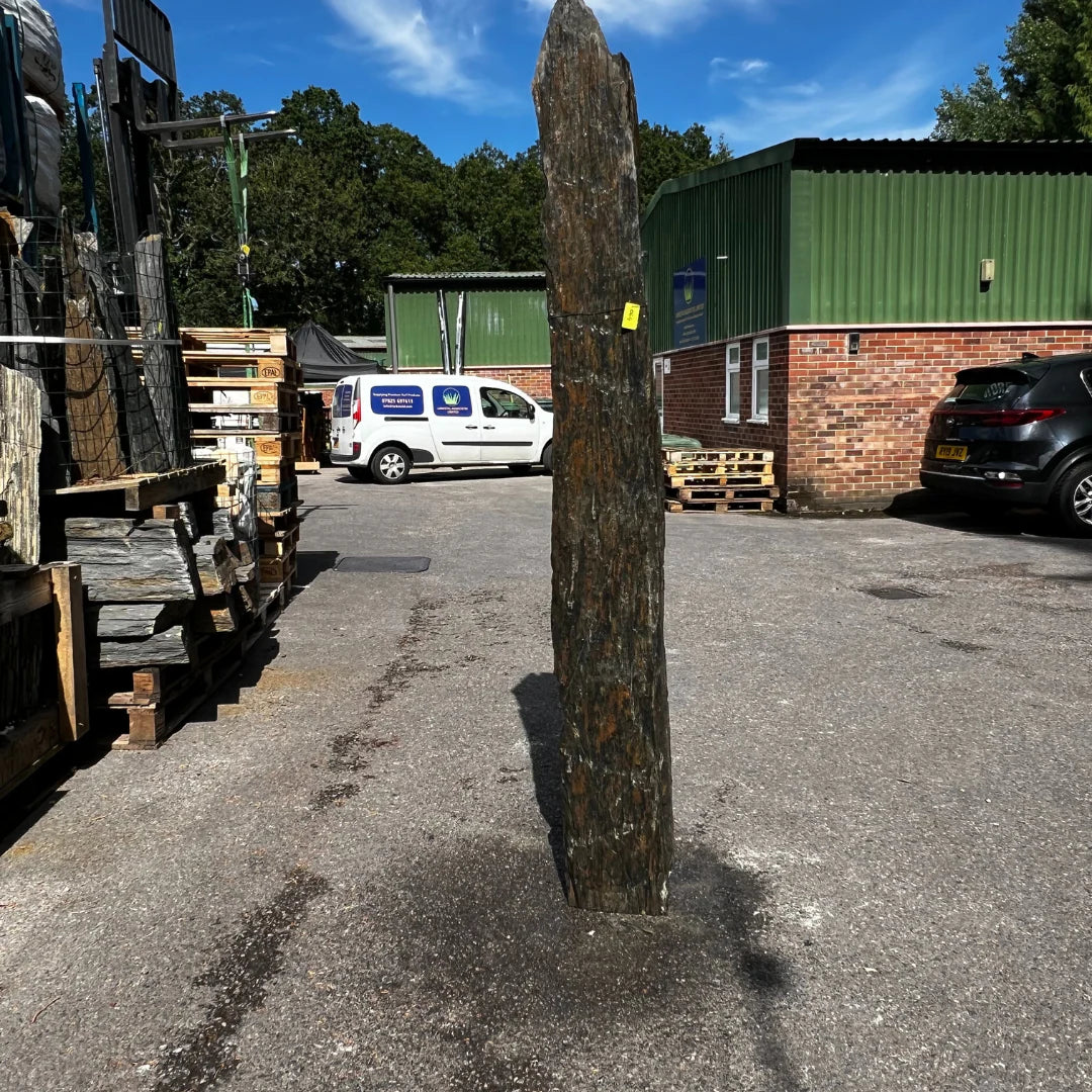 Tall natural stone garden ornament monolith adding height and texture to UK landscape designs.