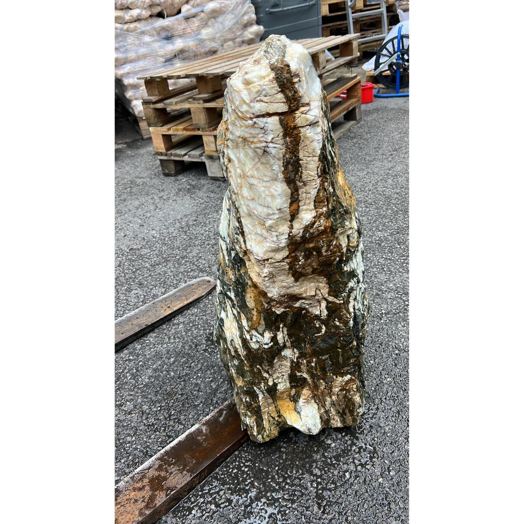 Tall outdoor monolith crafted from natural stone, adding height and texture to landscaped garden areas.