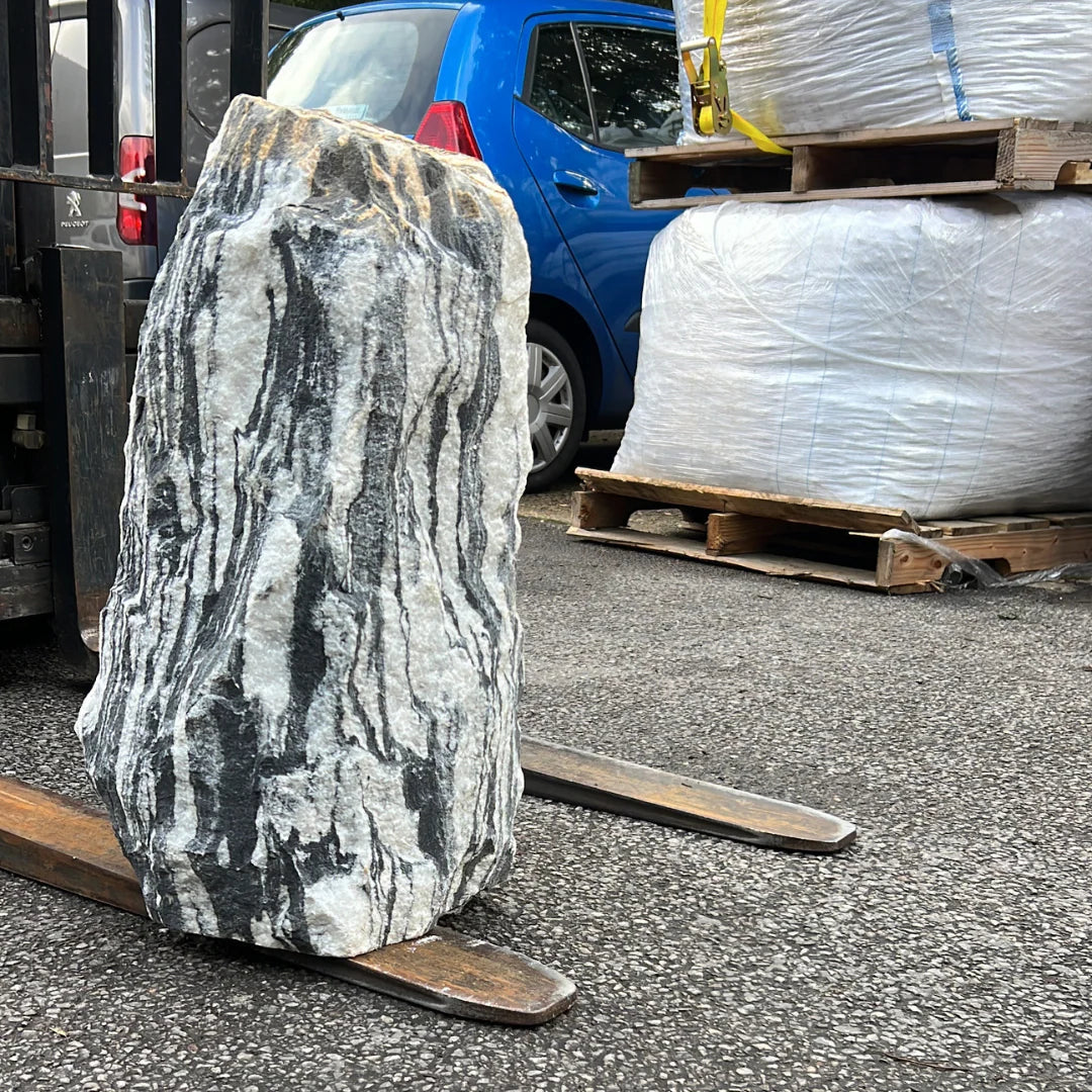 UK garden gravel and pebbles surrounding a decorative monolith, creating an elegant natural stone display.